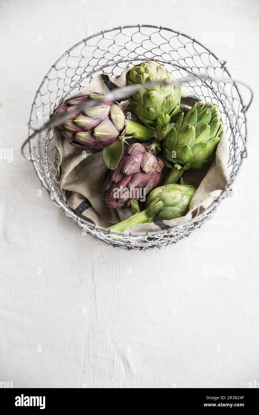 Artichokes in wire basket Stock Photo