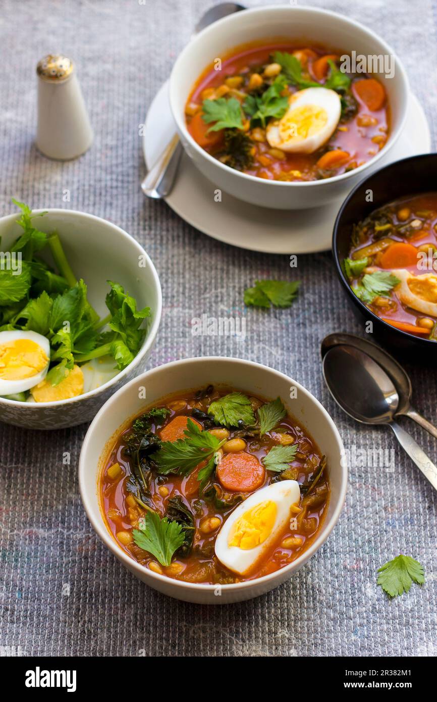 White bean soup with harissa, honey, egg and celery leaves Stock Photo