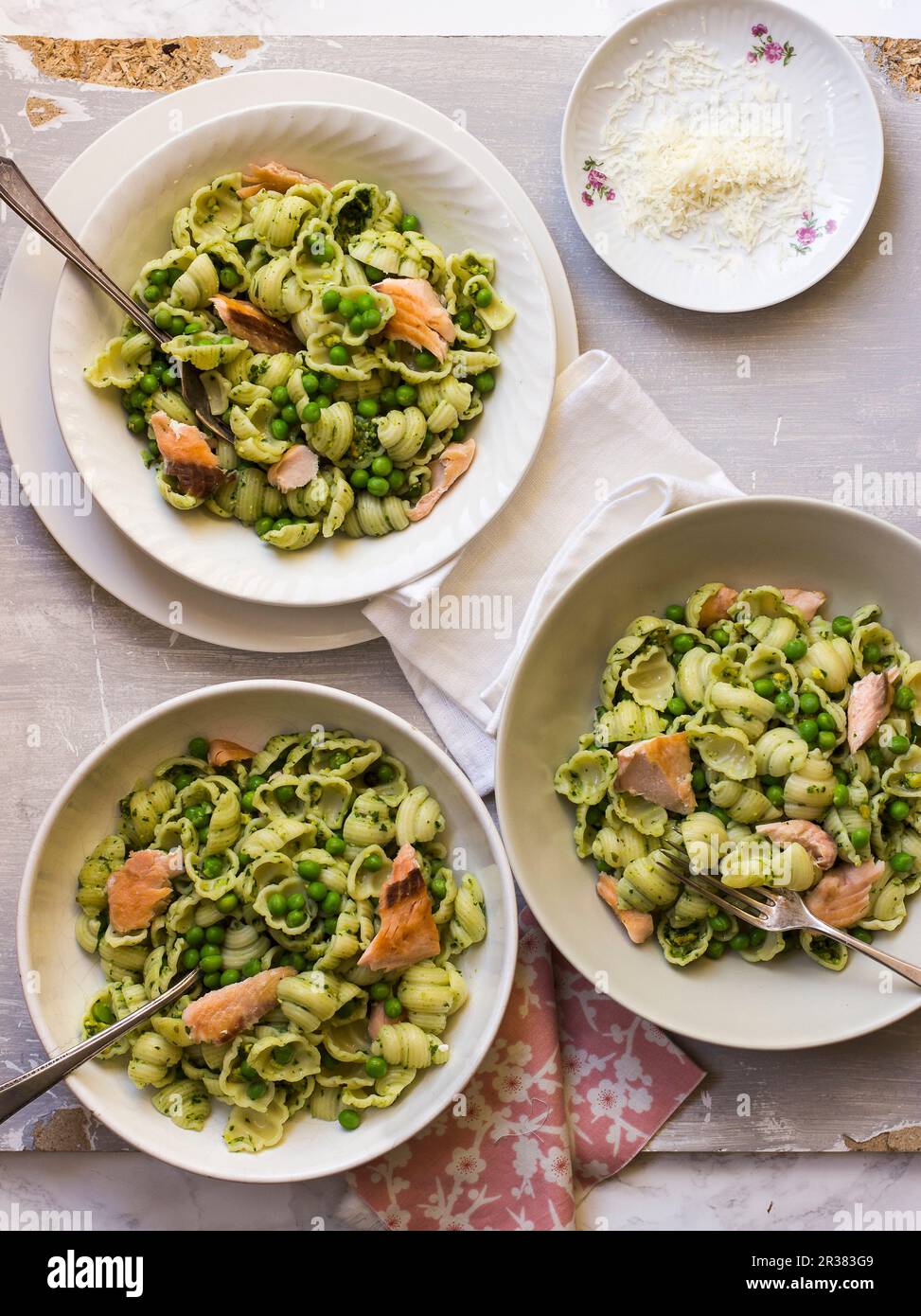 Pasta shells with pistachio pesto, salmon, peas and parmesan Stock Photo