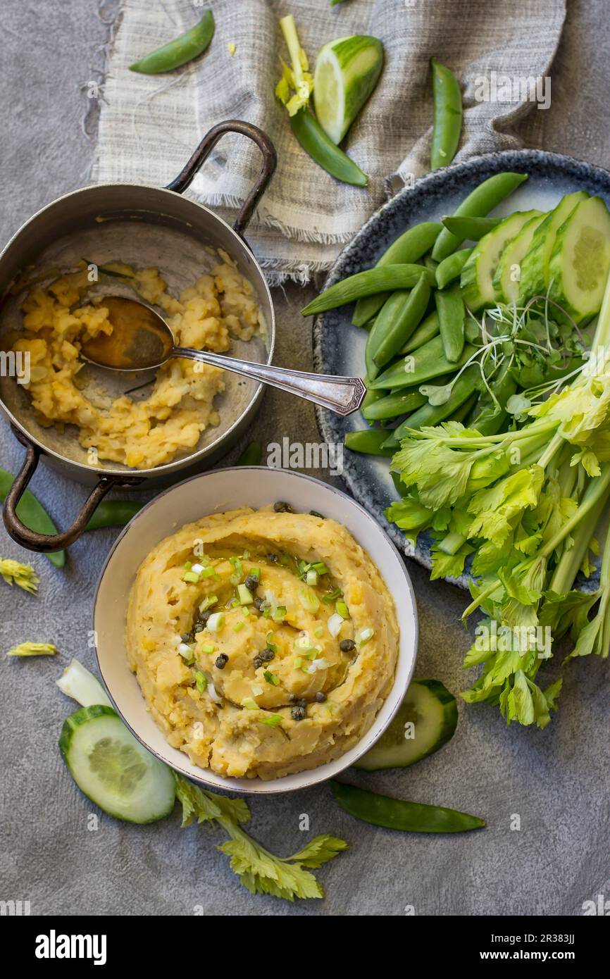 Yellow pea dip with cucumber, sugar snap peas, celery and pea leaves