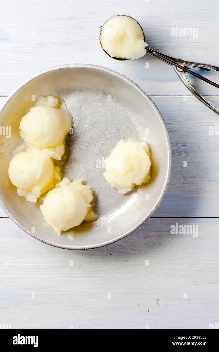 Scoops of melon sorbet and an ice cream scoop Stock Photo