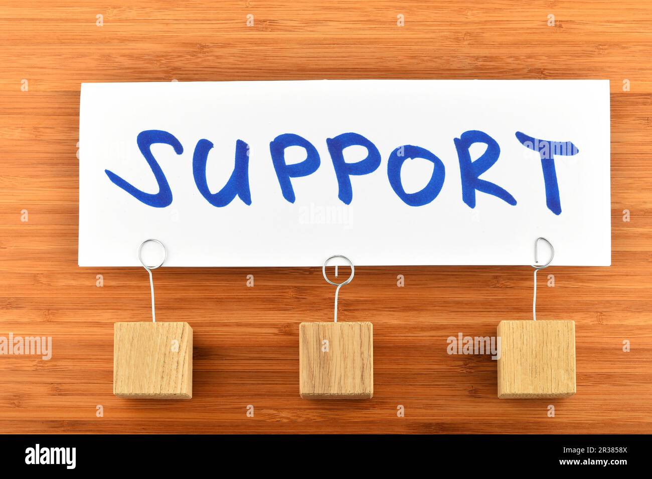 Support, one paper note on wooden background Stock Photo