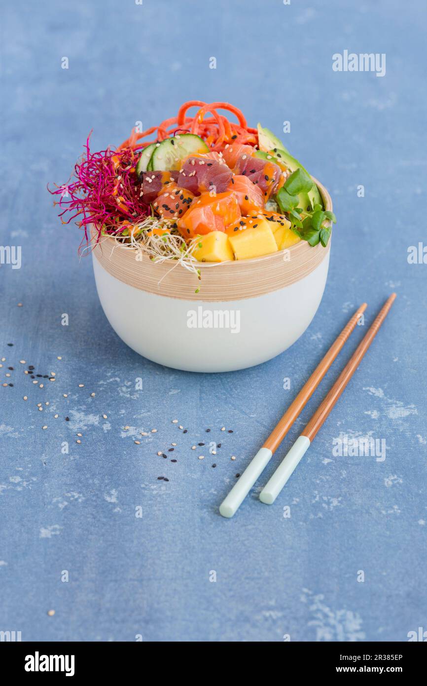 A Poke bowl with tuna, salmon, sushi rice, tobiko, avocado, carrots