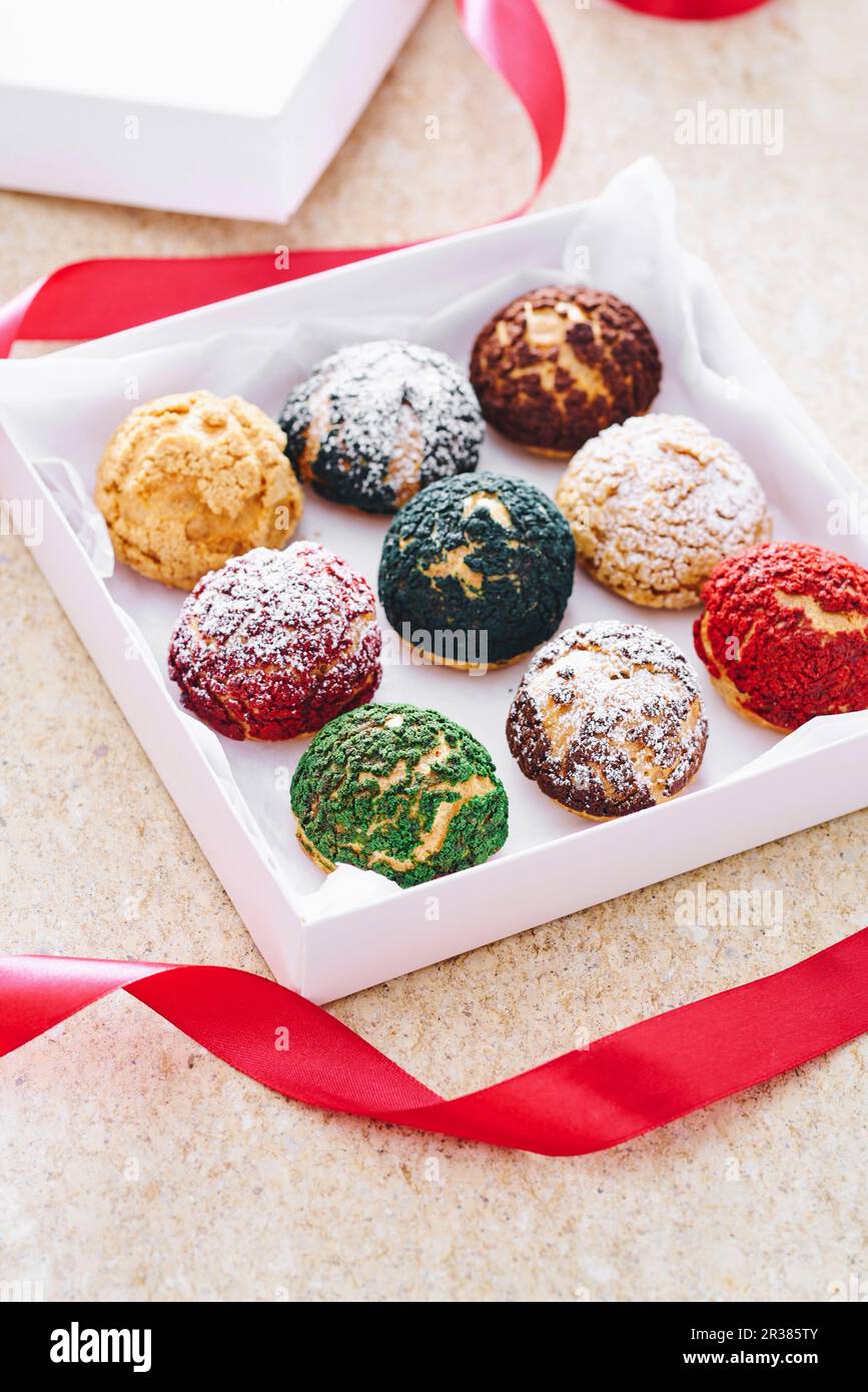 Different-coloured choux pastries in a gift box Stock Photo - Alamy