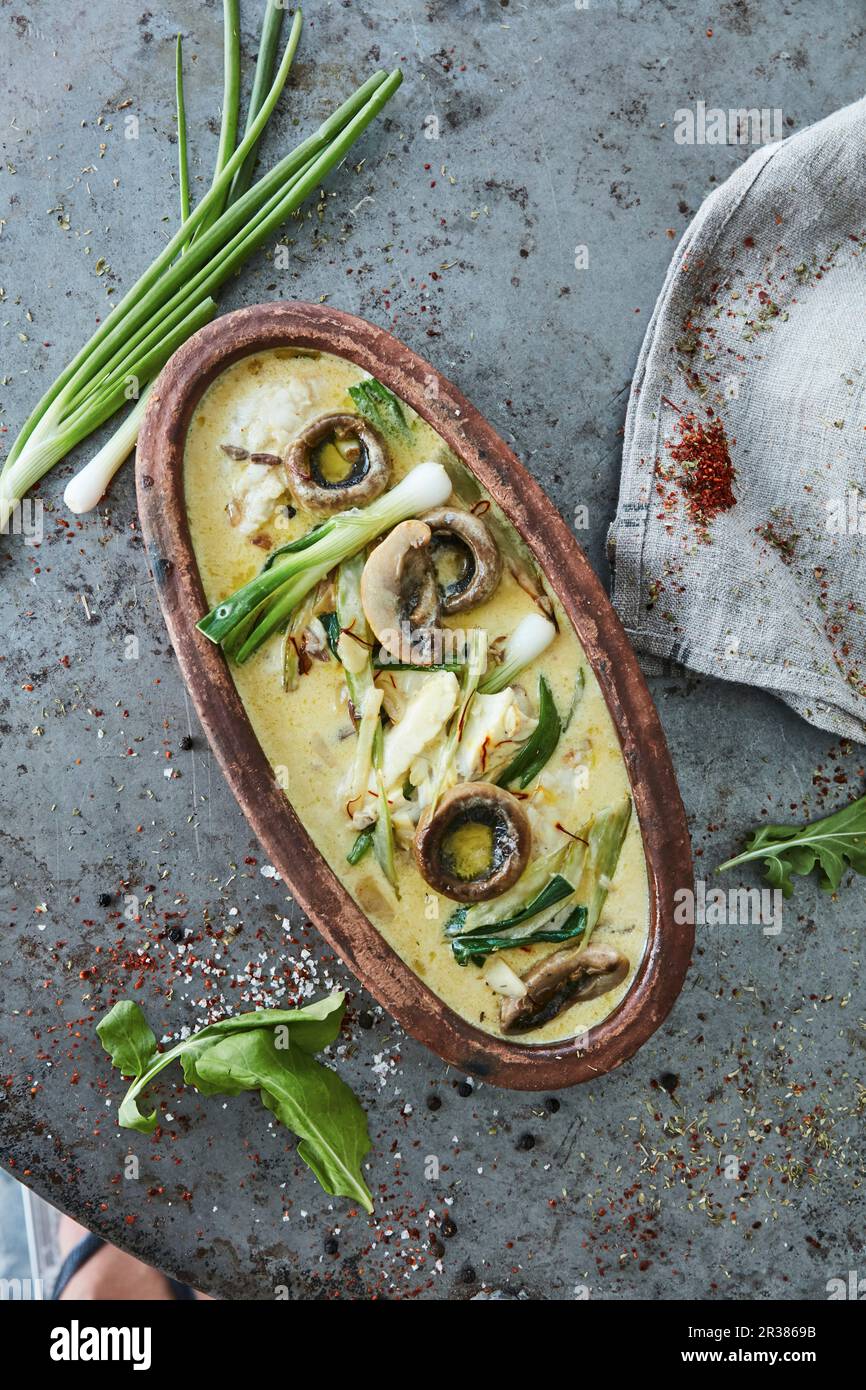 Oven cooked fish fillets with mushrooms and spring onions in cream
