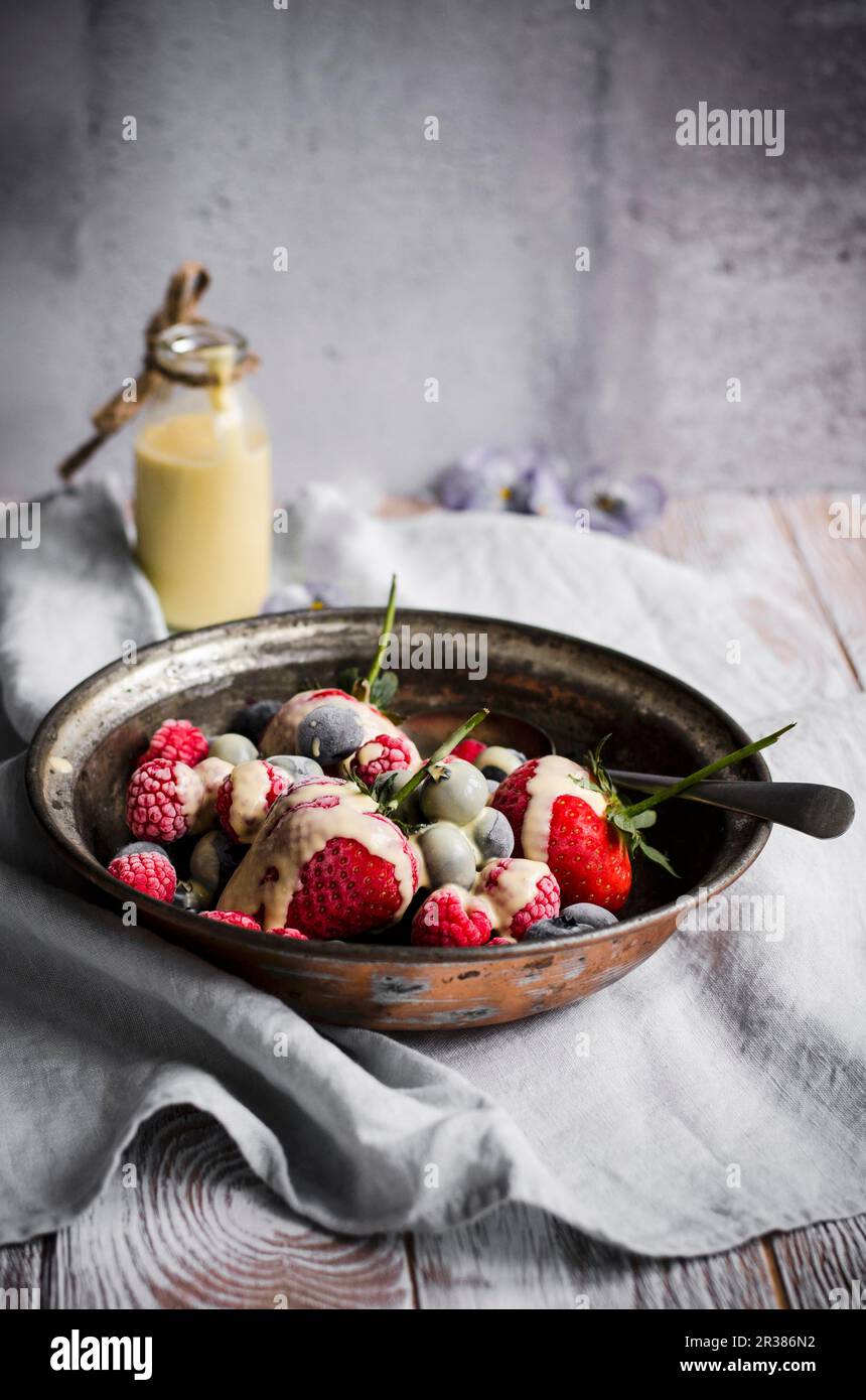 Frozen berries witha creme anglaise sauce, dairy free Stock Photo
