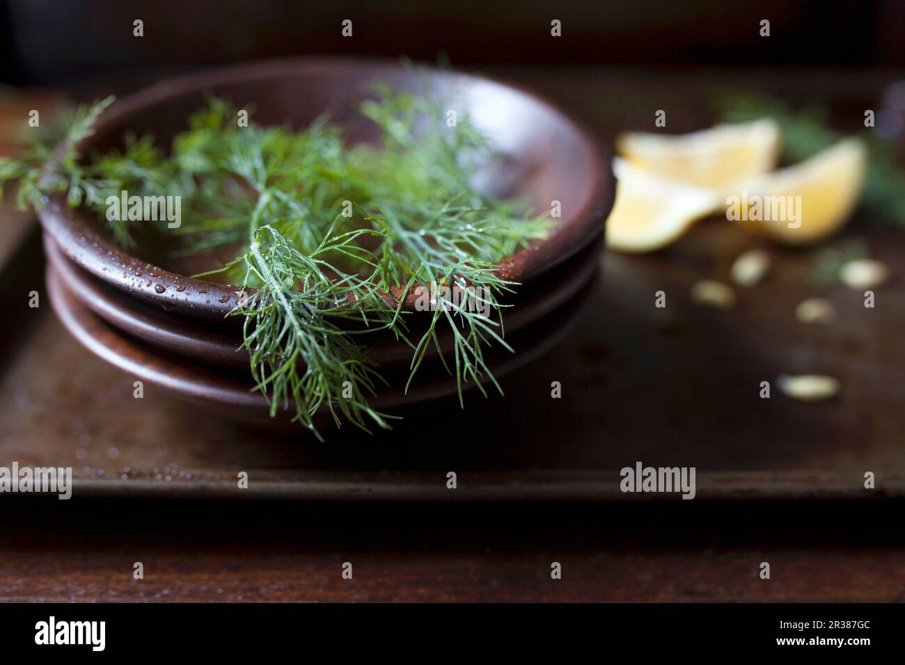 Fresh dill fronds in a wood bowl and lemon wedges Stock Photo Alamy