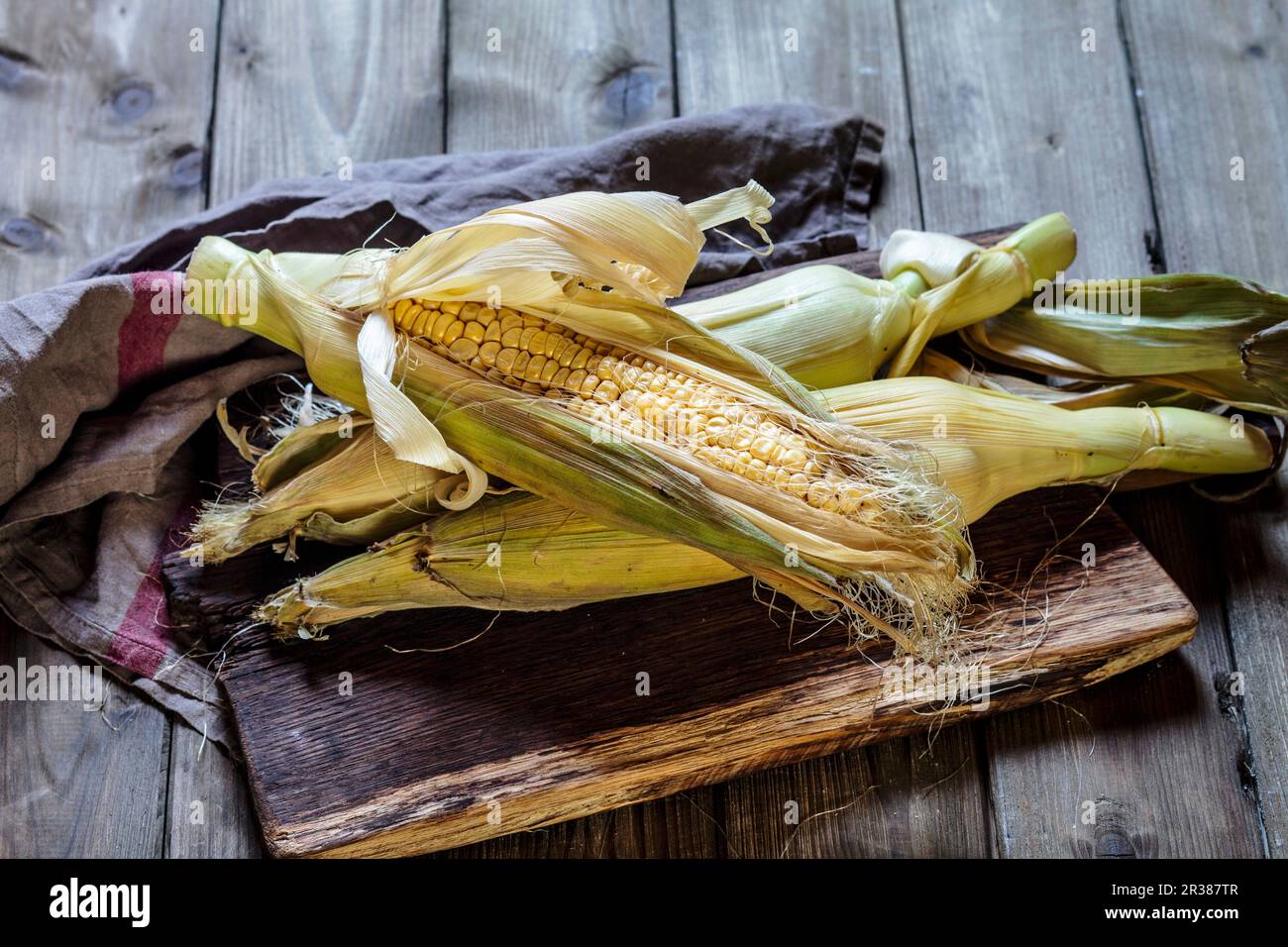 A corn cob on a wooden board Stock Photo