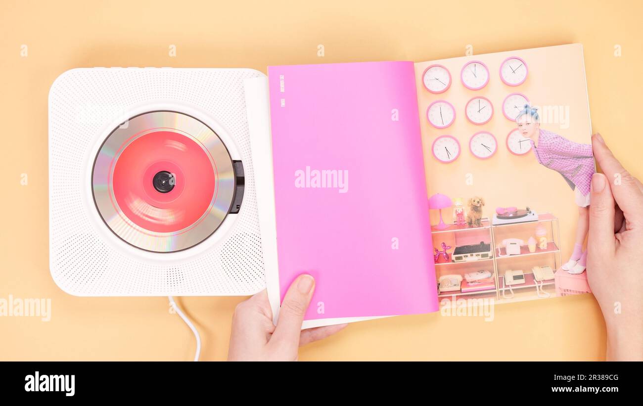 Hands holding Twice Between 1 and 2 mini Album photobook on yellow. Music CD player. South Korean girl group Twice. Space for text. Gatineau, QC Canad Stock Photo