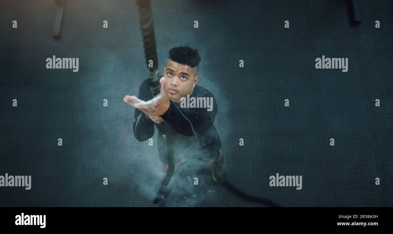 Rope climbing, fitness and man at gym from above for training