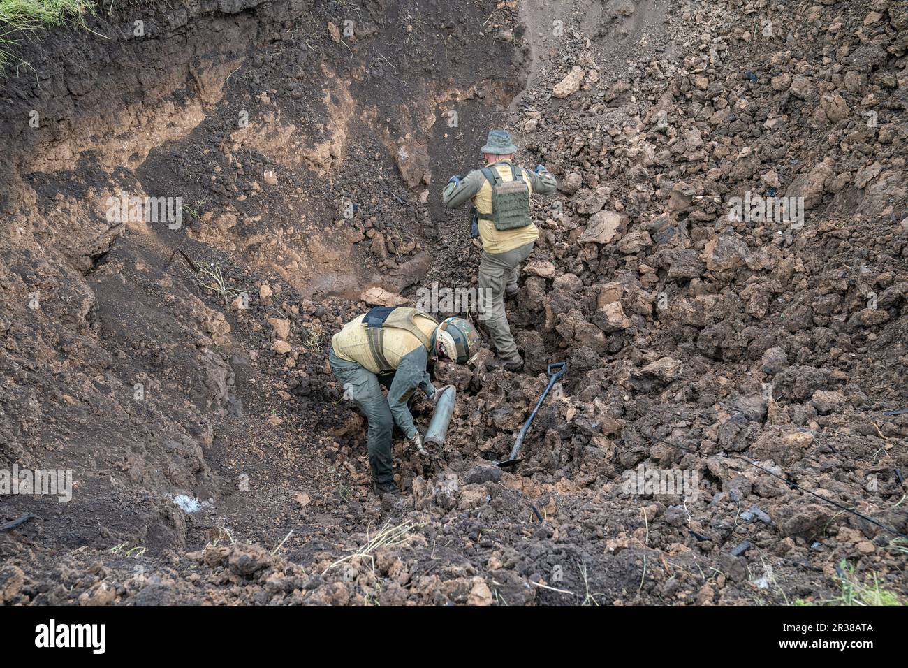 Members of National Guards of Ukraine de-mining unit prepare unexploded munition for controlled destruction by explosion near Kherson in Ukraine on May 22, 2023 Stock Photo