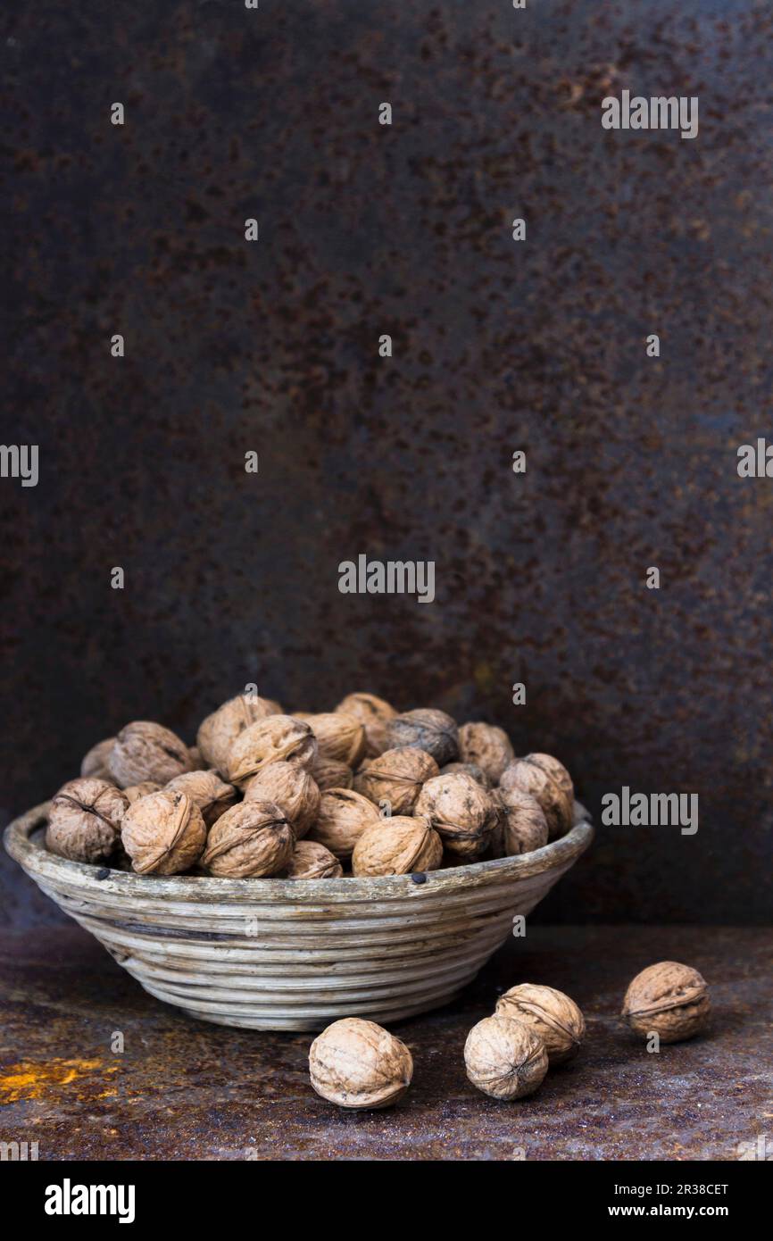 Walnuts in a basket against a rustic metal wall Stock Photo