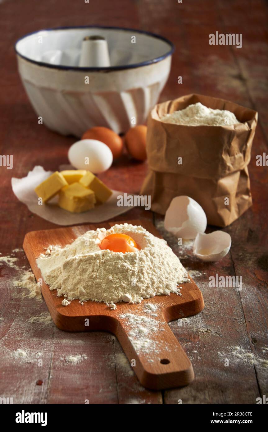 Flour, eggs, butter and a ringshaped baking tin for a Bundt cake Stock