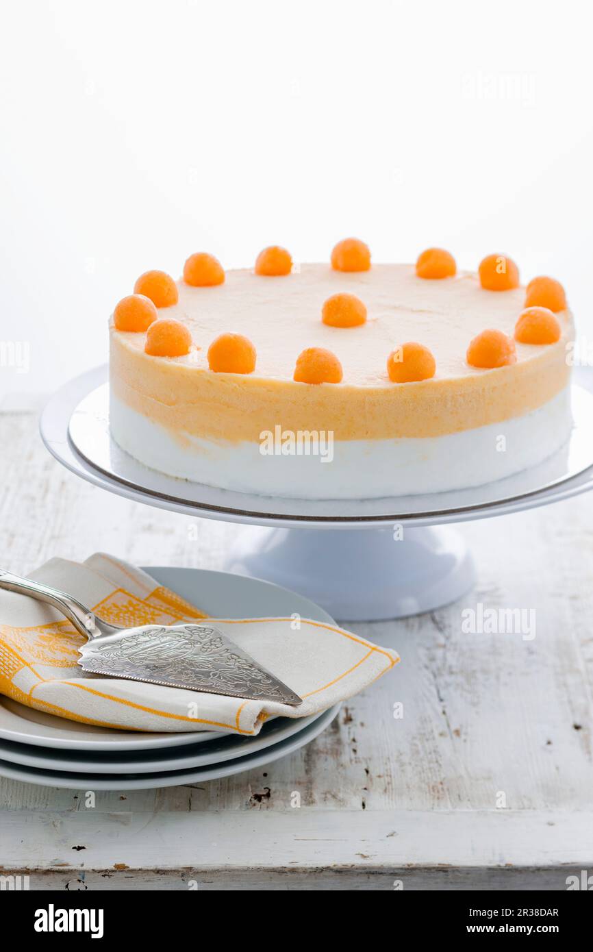 Gelato cake topped with honeydew melon balls on a cake stand Stock Photo
