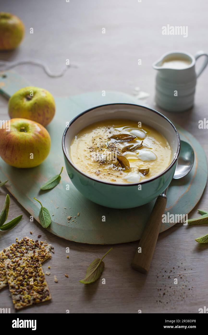 A bowl of celeriac and apple soup with sage and crackers Stock Photo