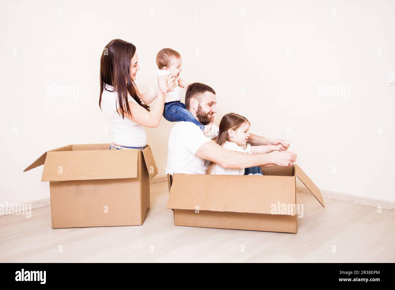 Family unpacking cardboard boxes at new home Stock Photo - Alamy