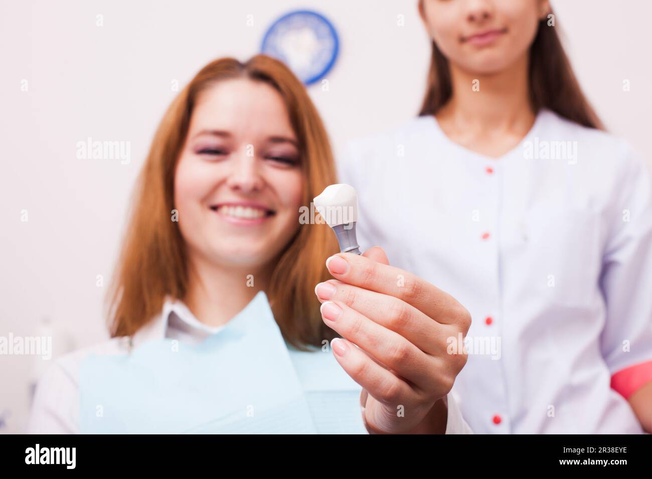 Woman in a Dentist office shows the plastic tooth Stock Photo Alamy
