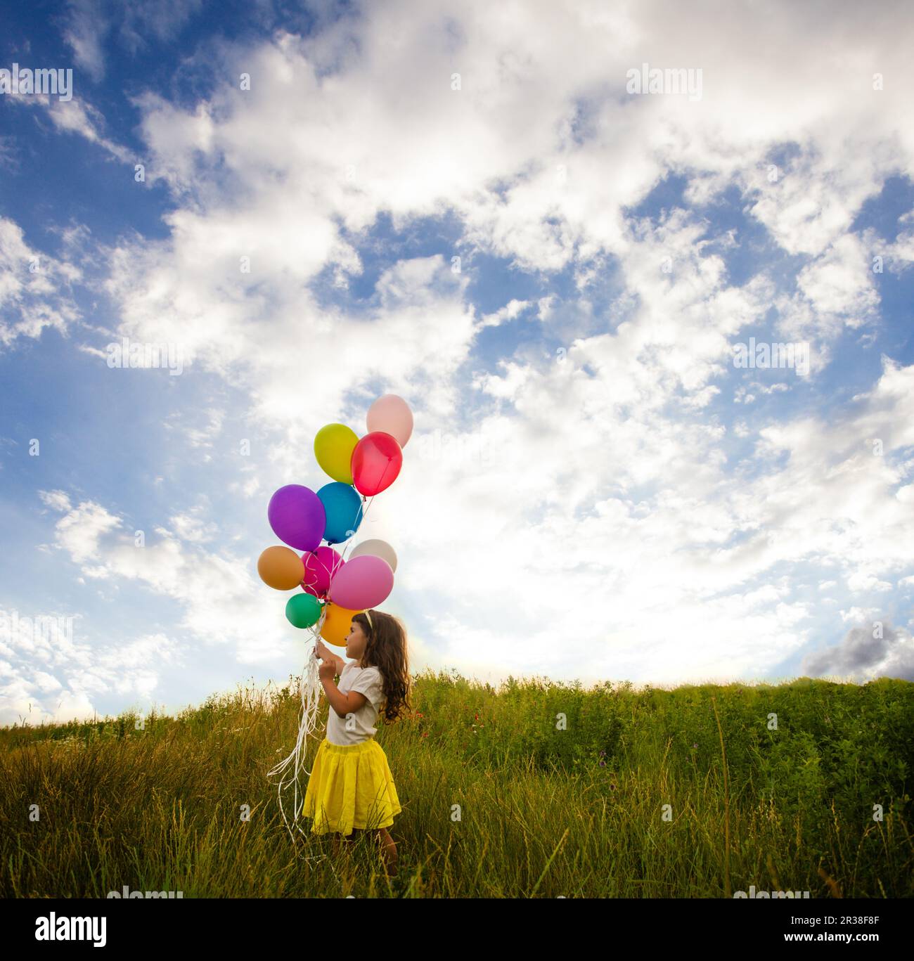 Smiling kid having fun with balloons outdoors Stock Photo