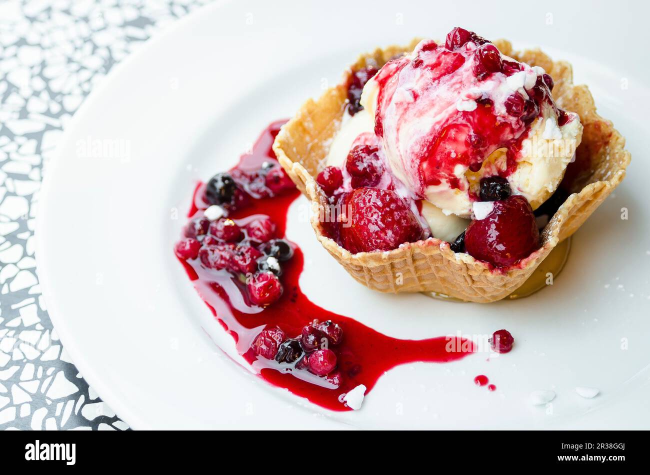 Vanilla ice cream with berry sauce in a wafer bowl Stock Photo - Alamy