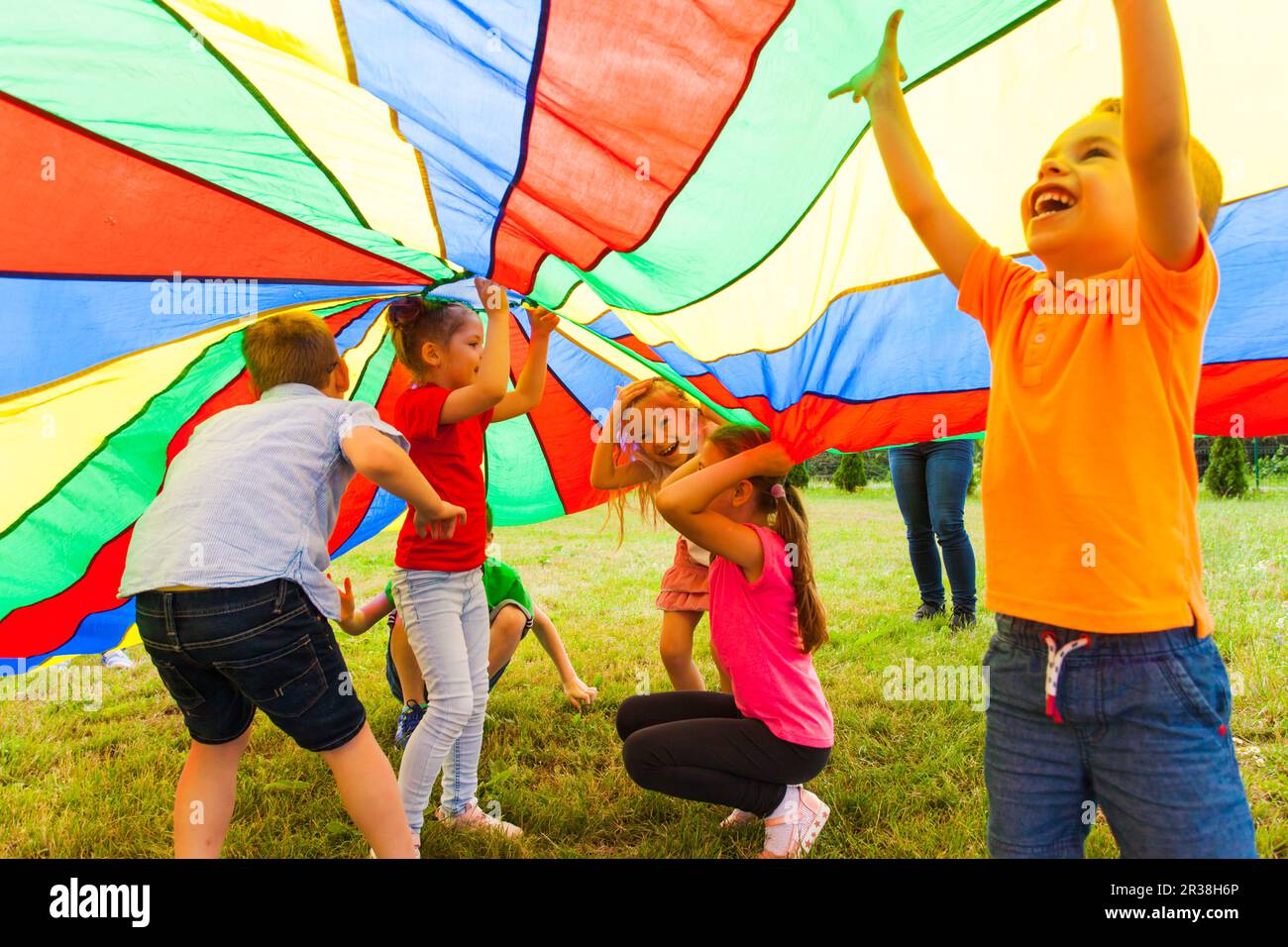 Close up view of children under the huge rainbow cover Stock Photo