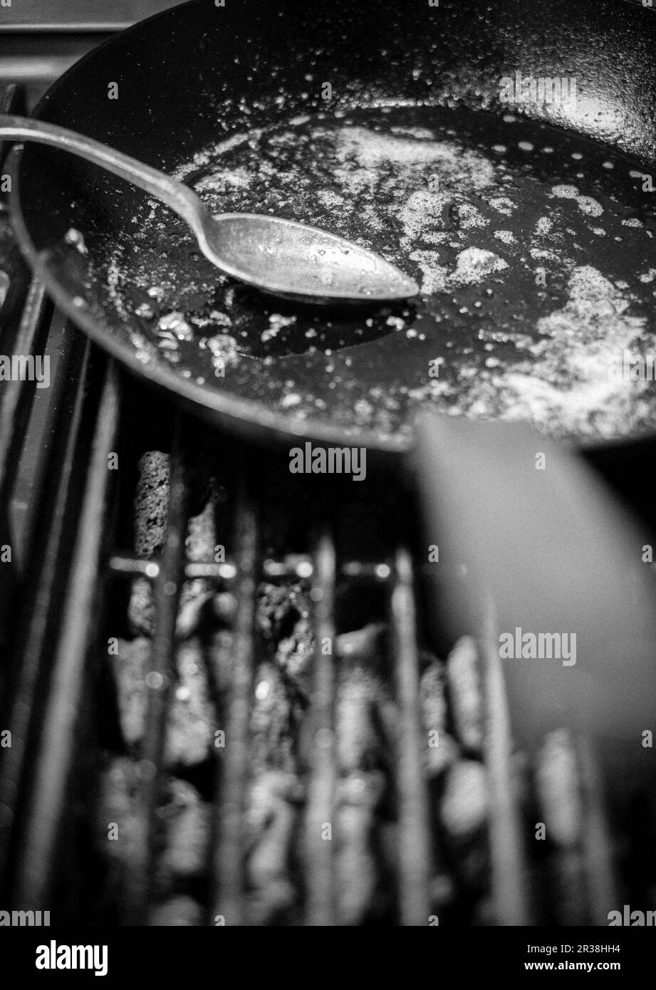 A spoon in a used pan on a grill Stock Photo Alamy