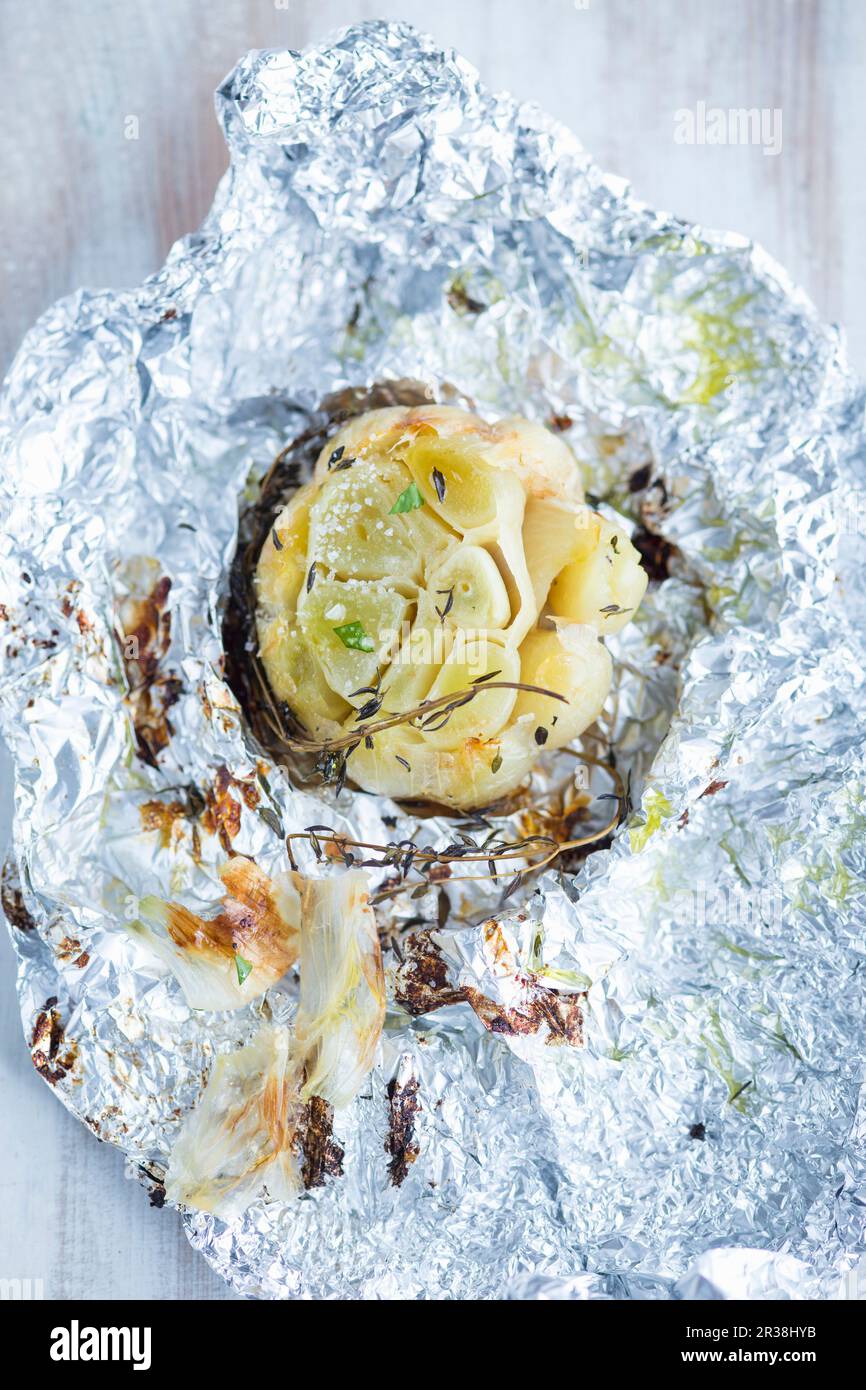 Baked garlic in aluminium foil Stock Photo Alamy