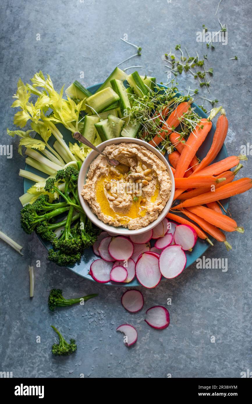 Homemade houmous with olive oil and pinenuts and raw vegetable for