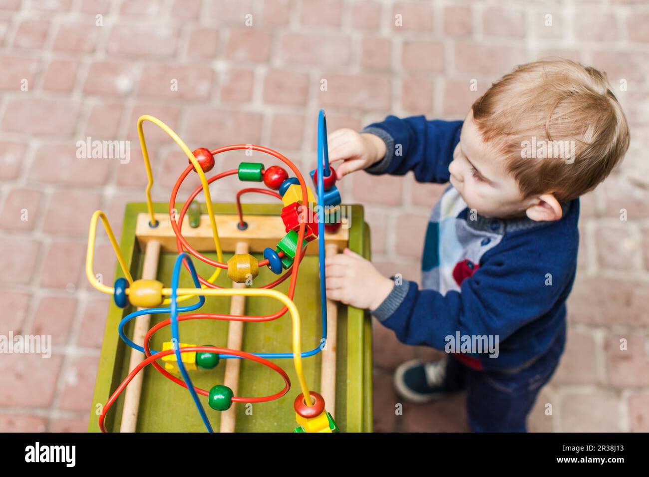 Little kid boy plays with a toy Stock Photo - Alamy