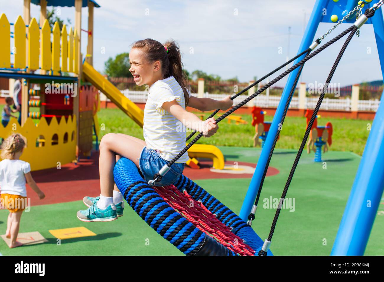 Various swings on the playground in the summer outdoors Stock Photo
