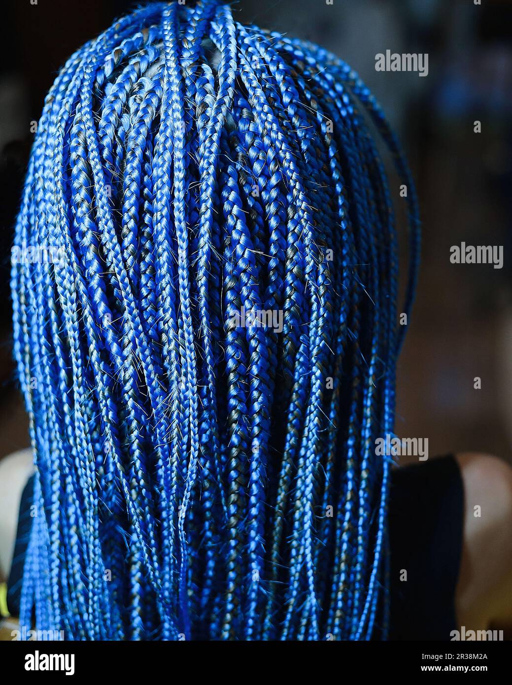 A lot of thin African plaits with artificial material, blond close-up on a light background, beauty studio Stock Photo
