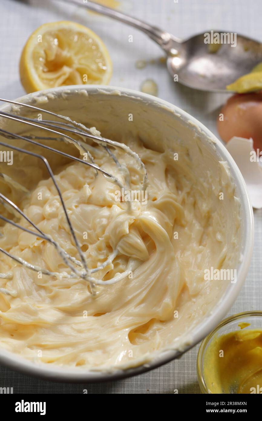 Mayonnaise being stirred in a bowl Stock Photo