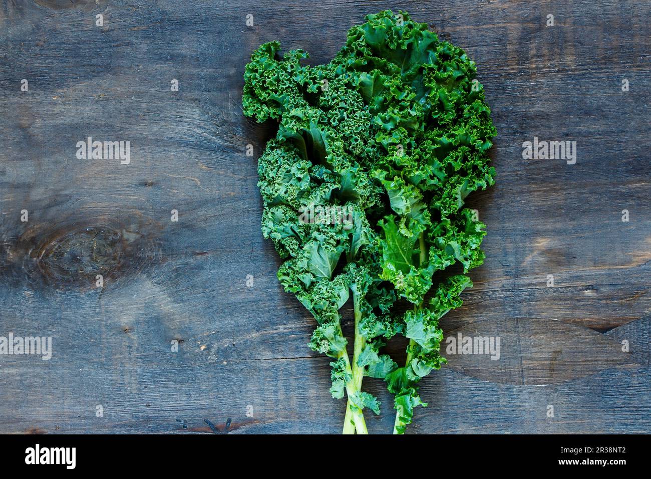 Raw green curly kale on rustic wooden background Stock Photo