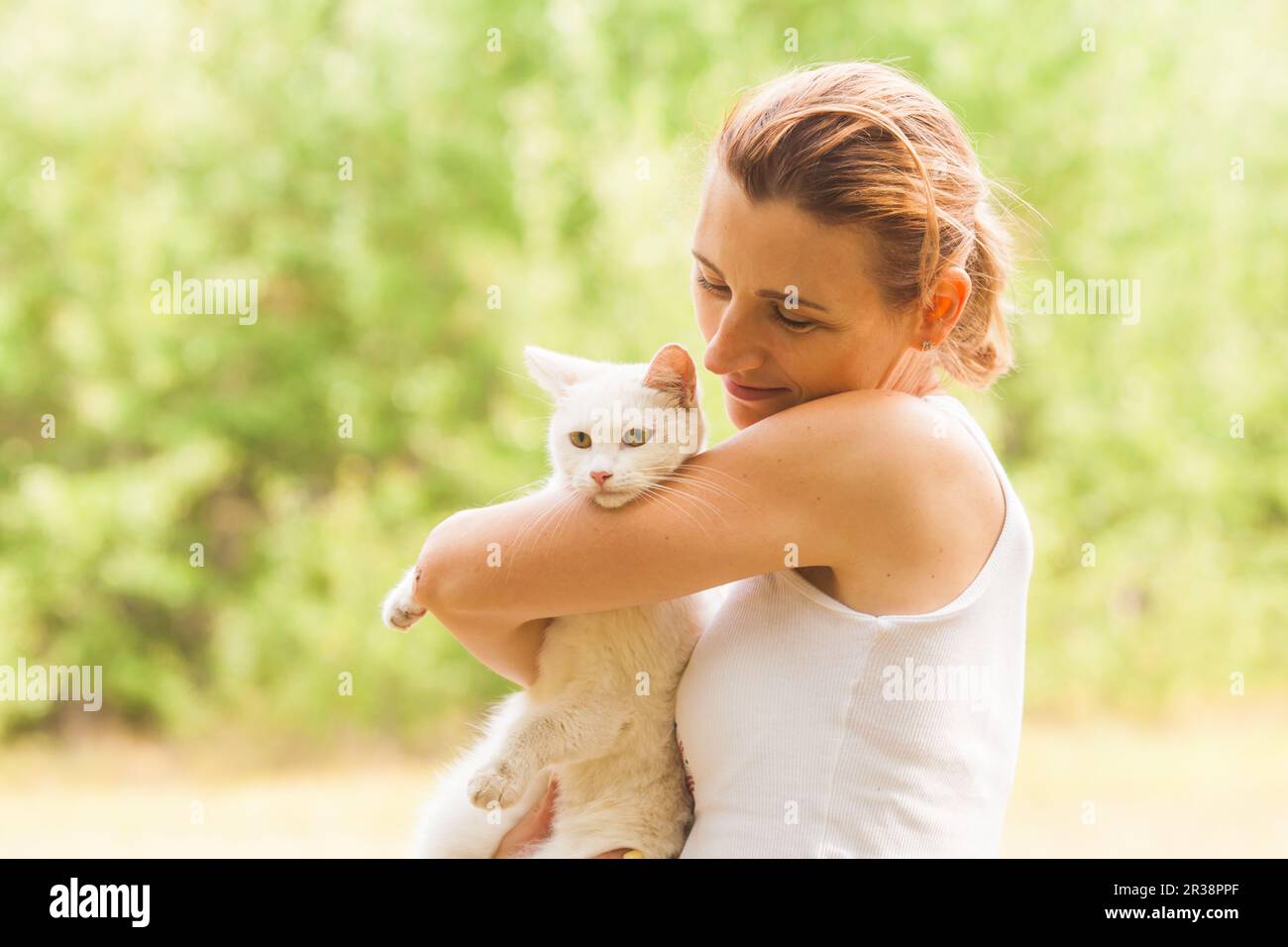 Woman petting her lovely cat during summer city walk Stock Photo