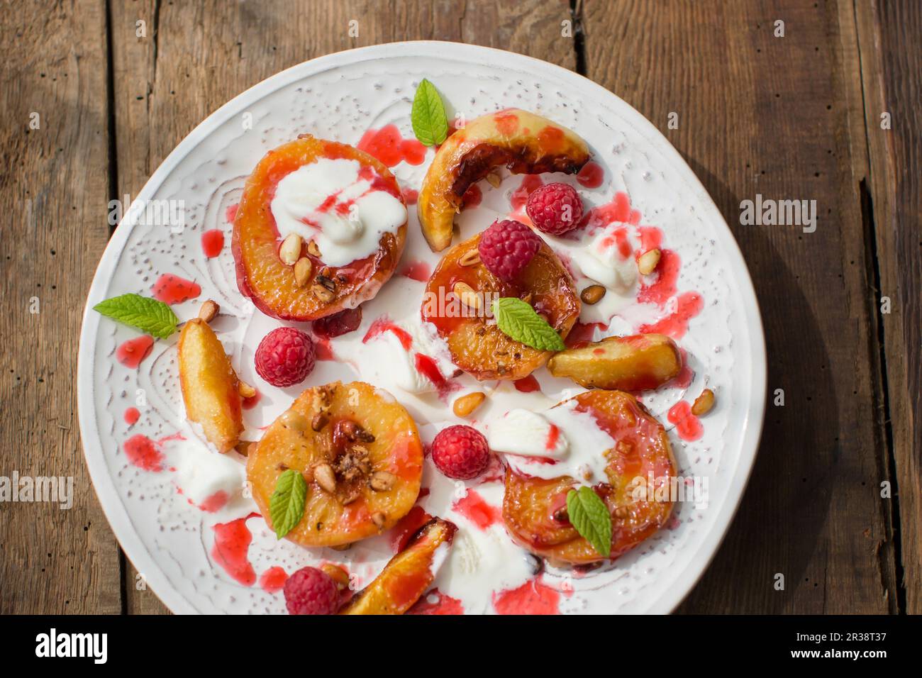 Peaches and pinenuts roasted in honey Stock Photo