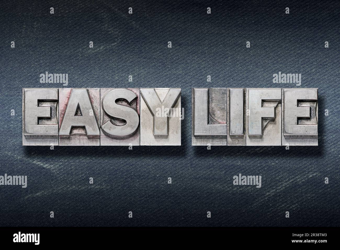 easy life phrase made from metallic letterpress on dark jeans background Stock Photo