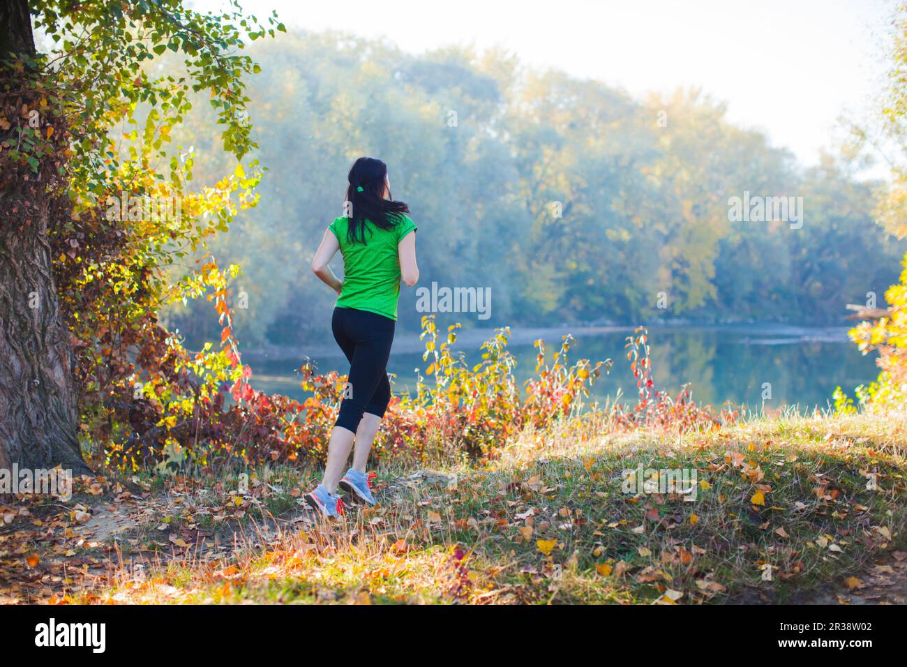 Sporty girl running on the pathway in the forest Stock Photo
