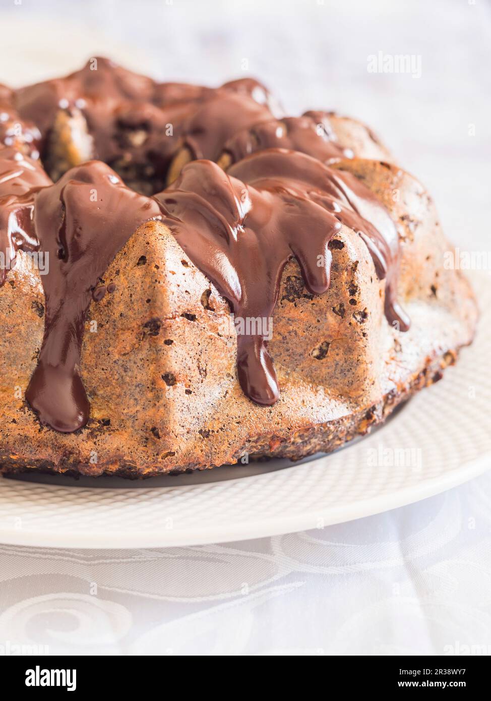 Flourless (almond flour) gluten and sugar free Easter gugelhupf cake with banana, poppy seeds and chocolate icing Stock Photo