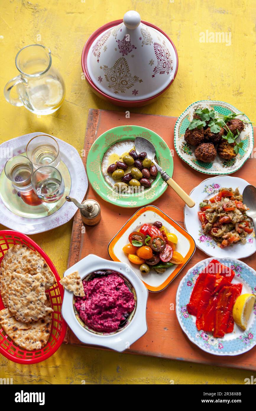 Mutabal, olives, roast peppers, tomate salad, beetroot hummus and flat bread Stock Photo
