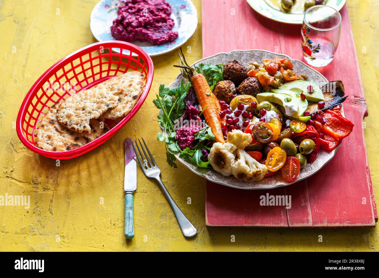 Beetroot hummus, falafel, flat bread, mezze, mutabal, olives, peppers, pommigranet, roast carrots, roast cauliflower, roast potates, salad Stock Photo