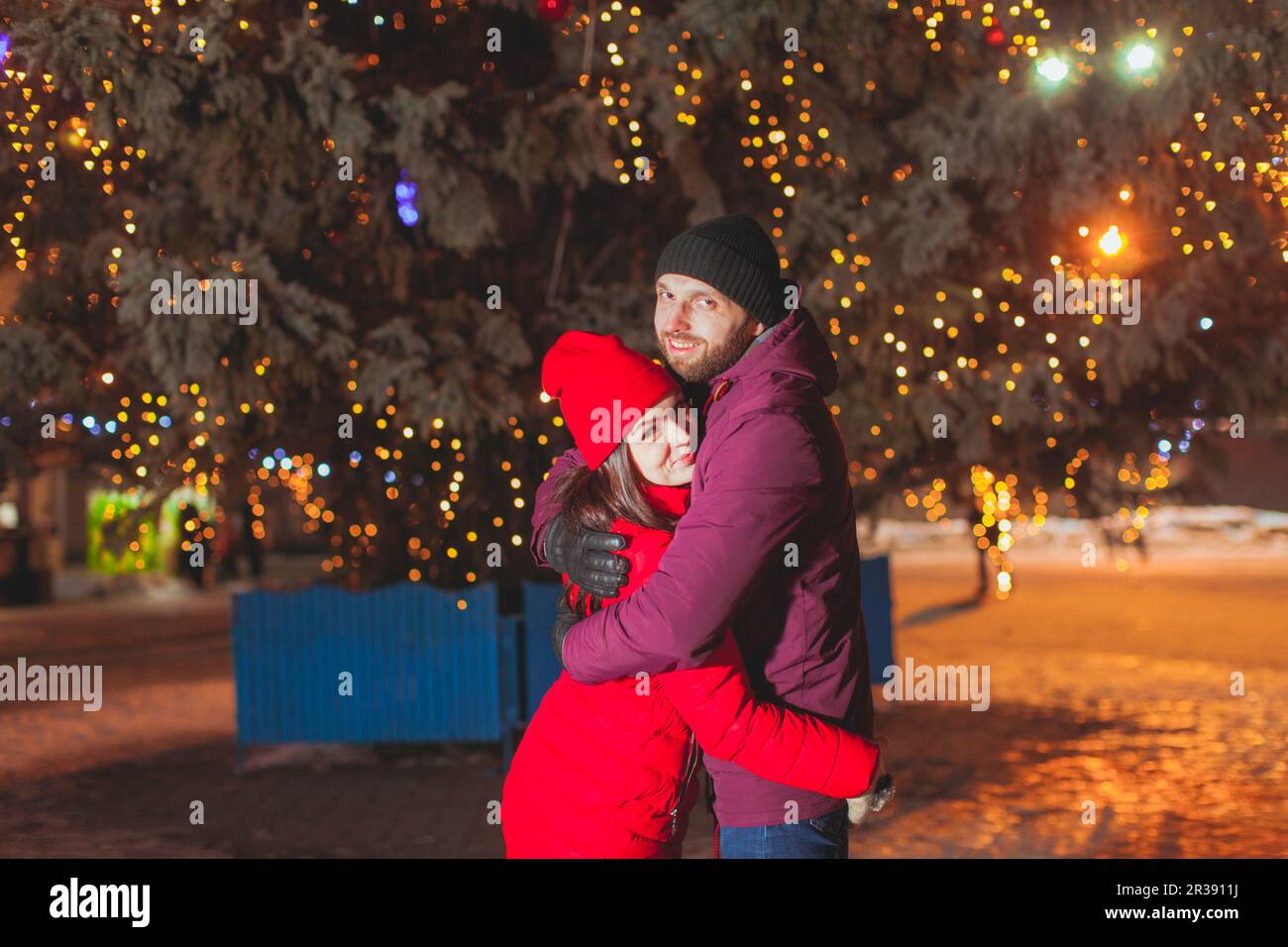 Hugging couple on the evening winter city square Stock Photo