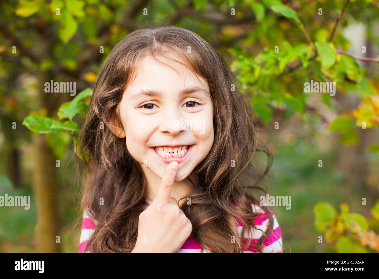 Portrait of girl pointing with finger her new adult tooth Stock Photo