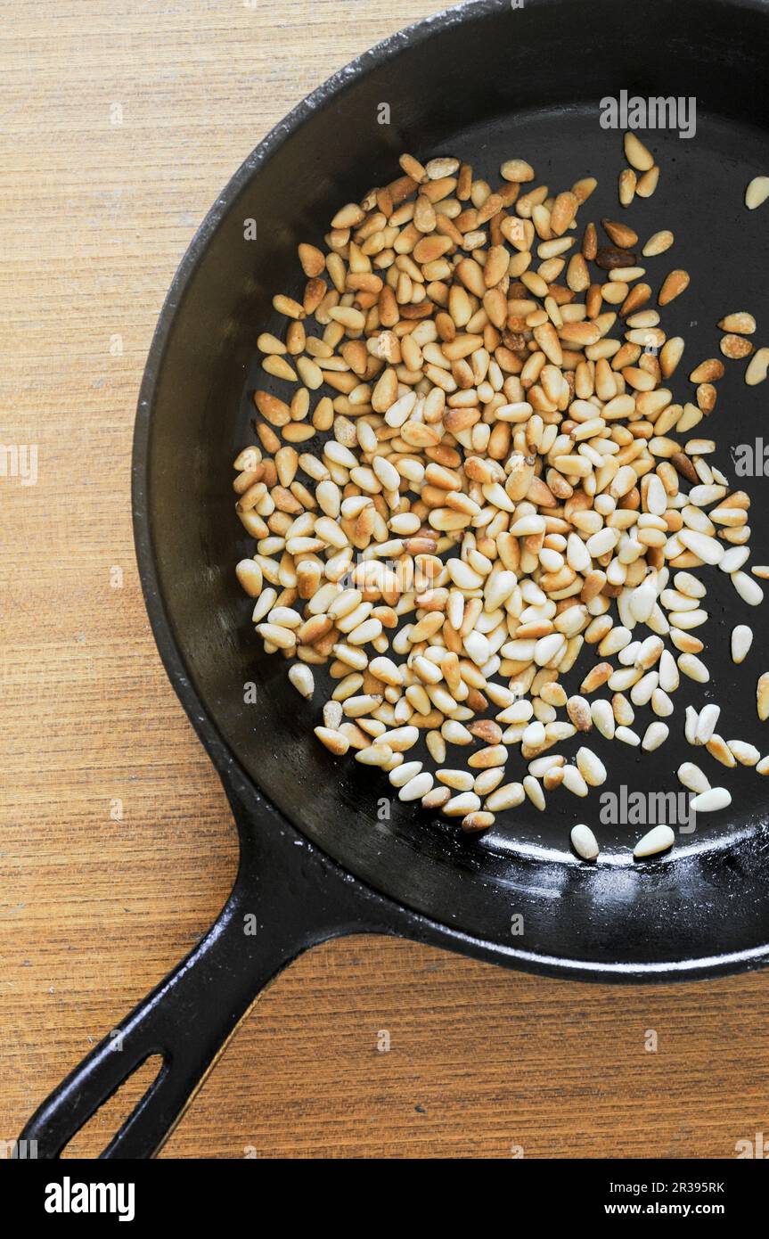Iron frying pan roasting pine nuts Stock Photo Alamy