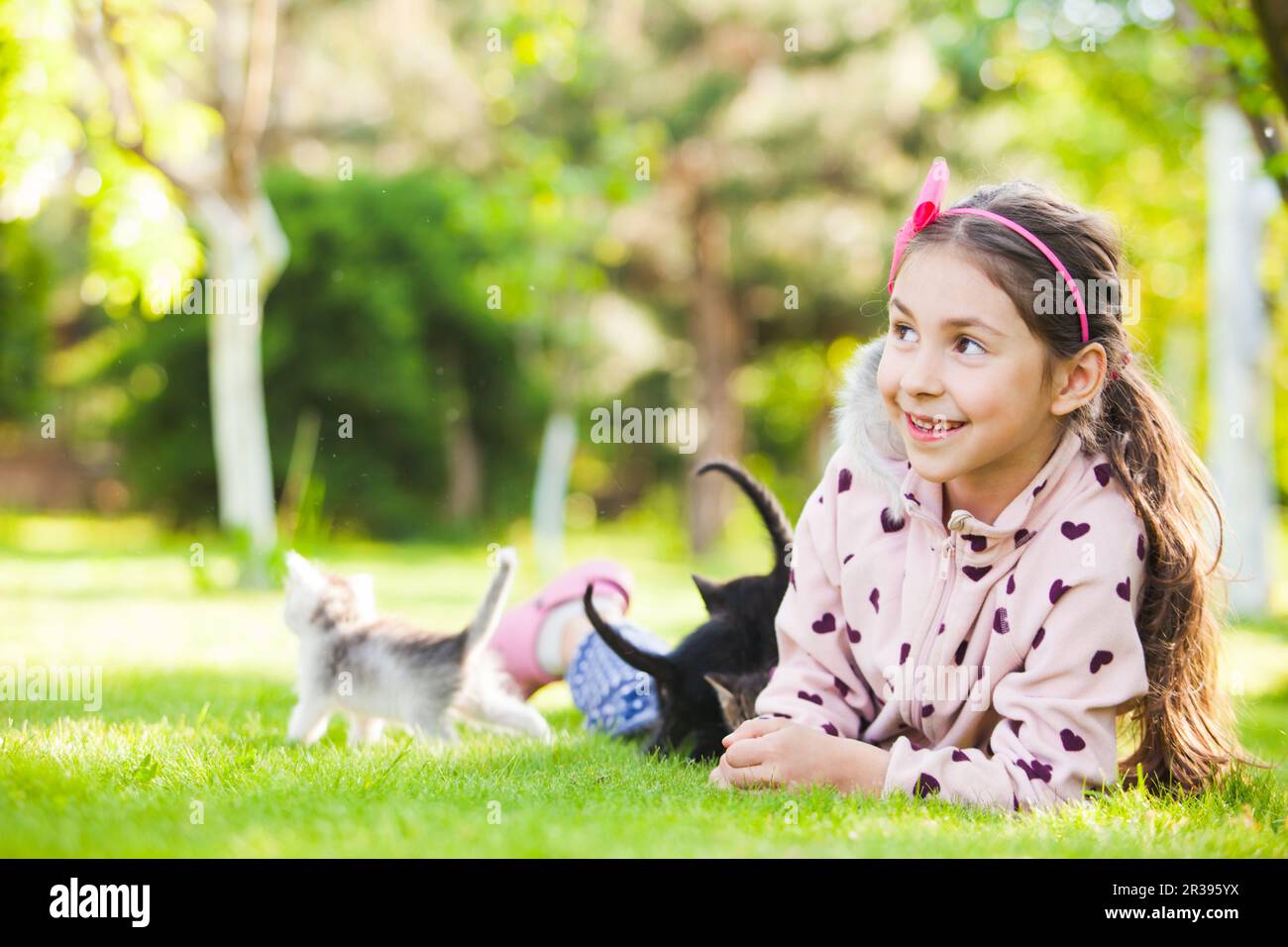 Outdoor portrait of cute girl playing with small kittens Stock Photo