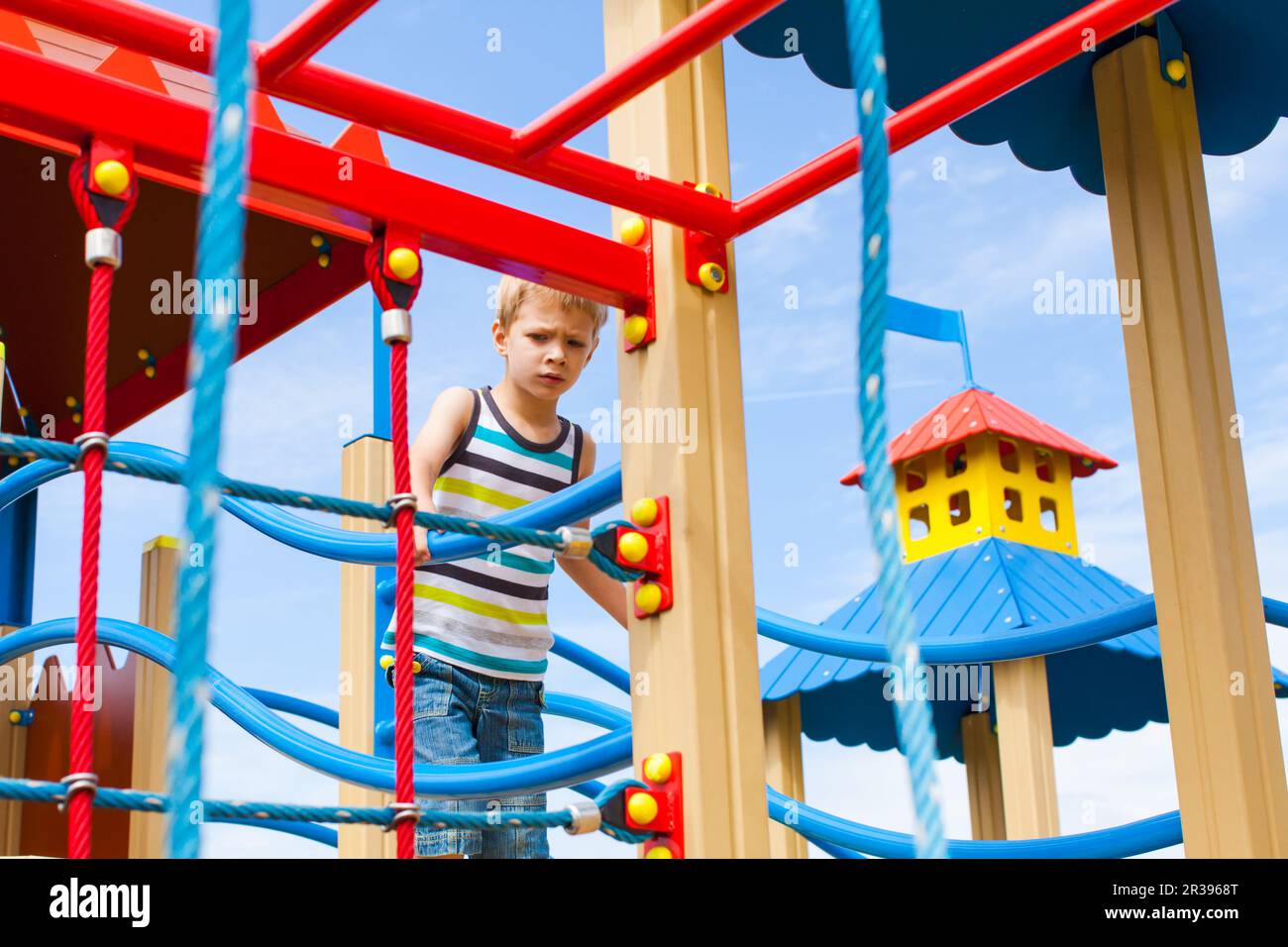 Cute boy playing alone outdoors in amusement park Stock Photo