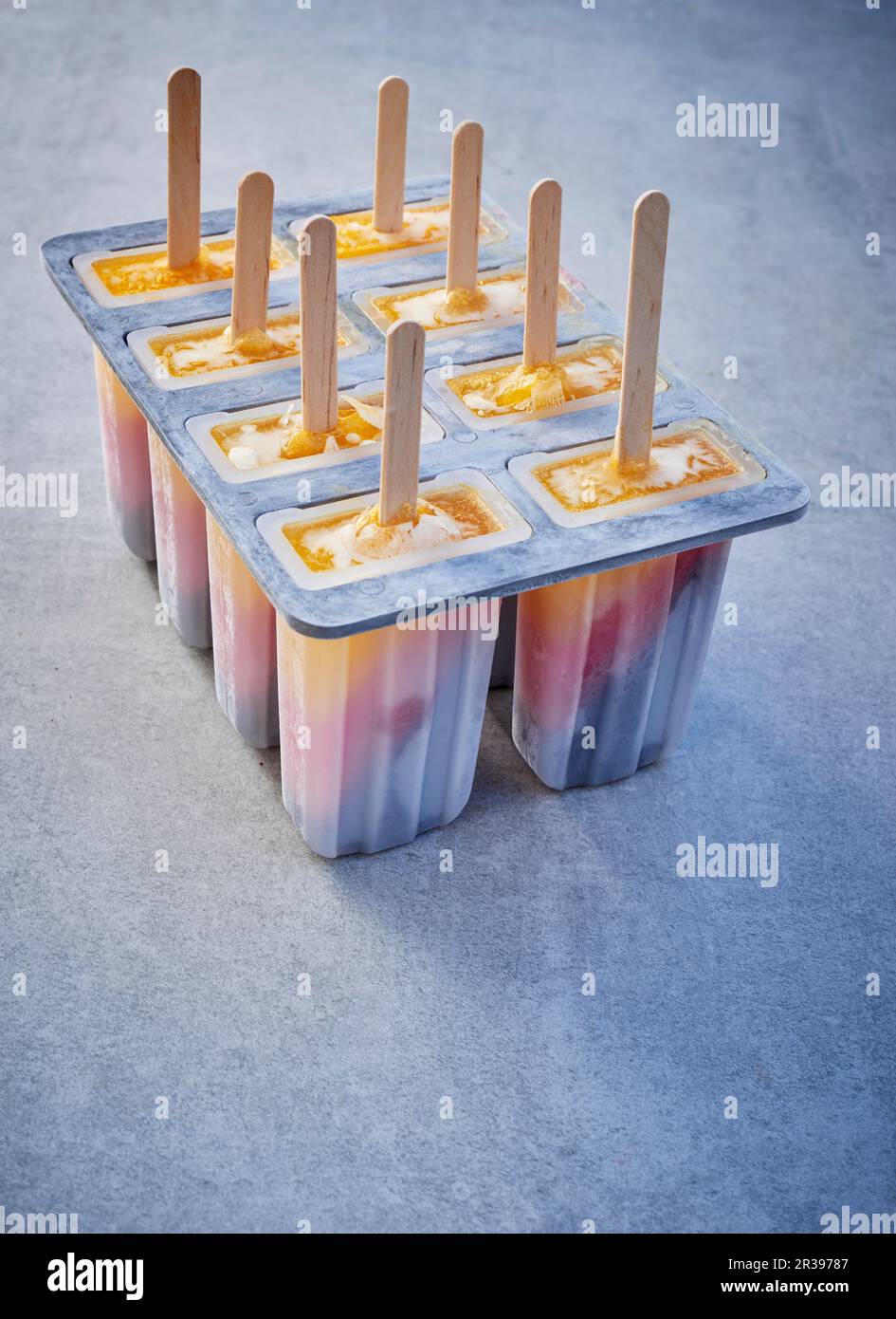 https://c8.alamy.com/comp/2R39787/tri-coloured-ice-cream-sticks-in-lolly-moulds-on-a-grey-surface-2R39787.jpg