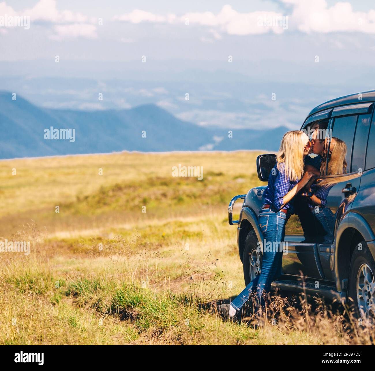 Couple arrived on an SUV high up in the mountain Stock Photo