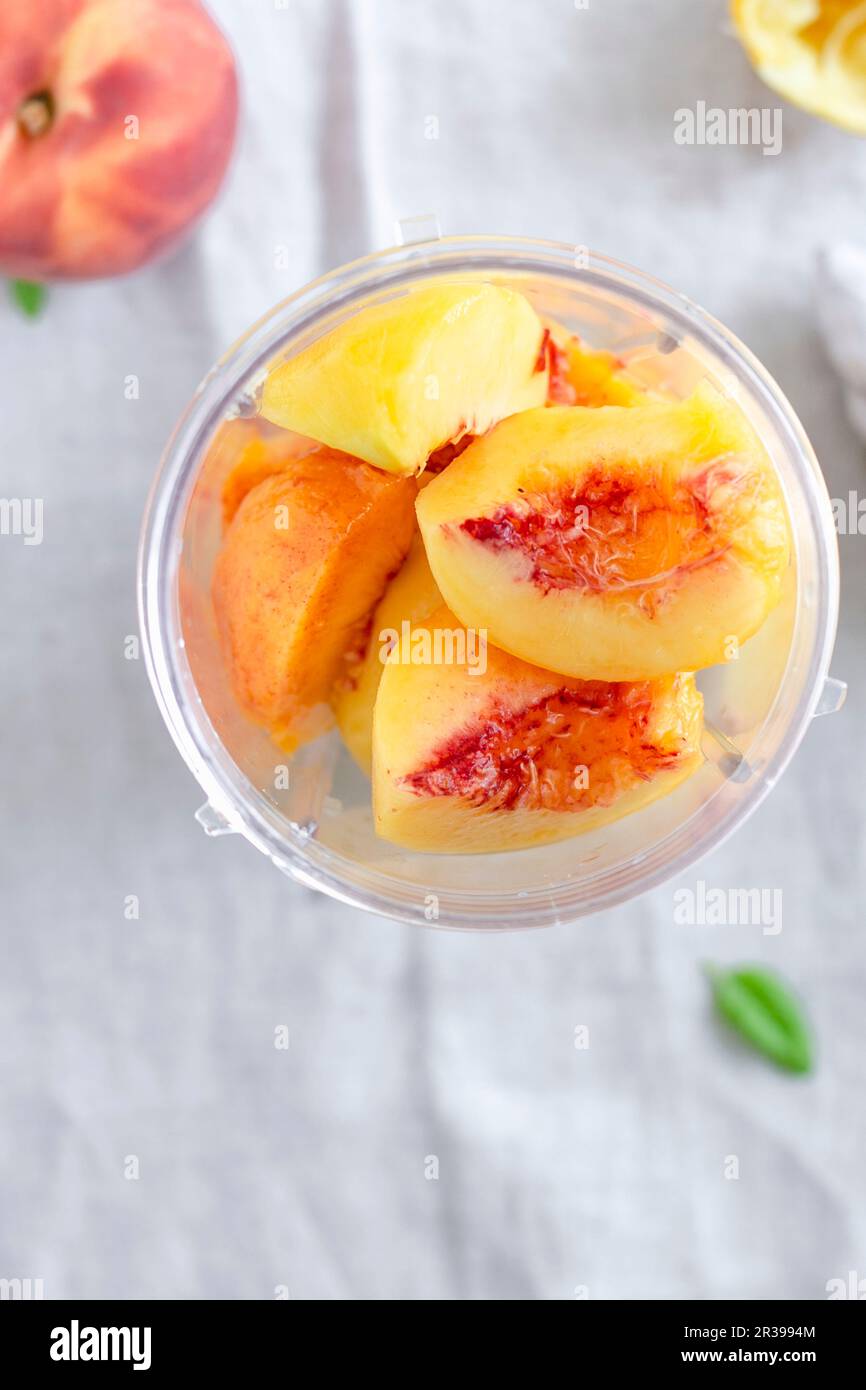 Peeled peach pieces in a blender Stock Photo