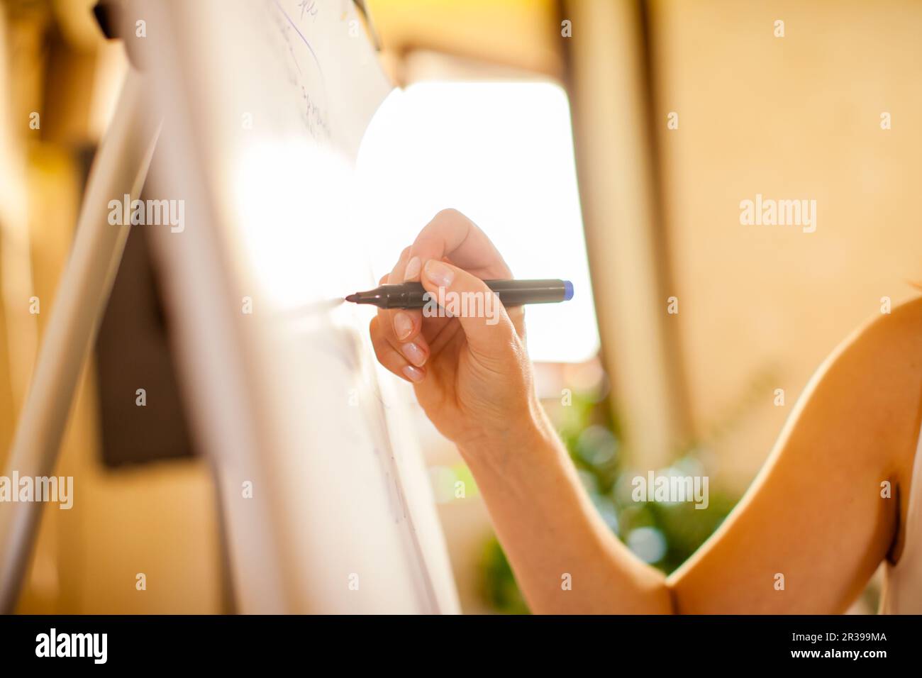Female writes something with a marker on white board. Stock Photo