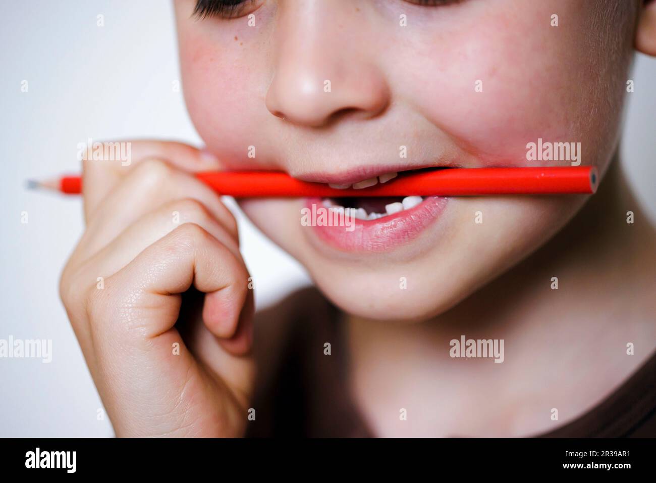 Berlin, Deutschland. 19th May, 2023. Symbolic photo on the subject of chewing on a pen. A boy is chewing on a colored pencil with his teeth. Berlin, May 19, 2023 || Model release available Credit: dpa/Alamy Live News Stock Photo