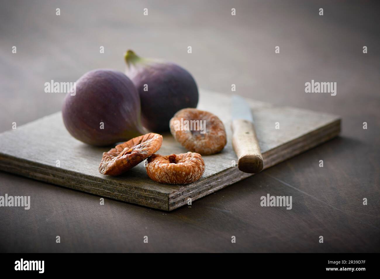 Fresh and dried figs on a wooden board Stock Photo